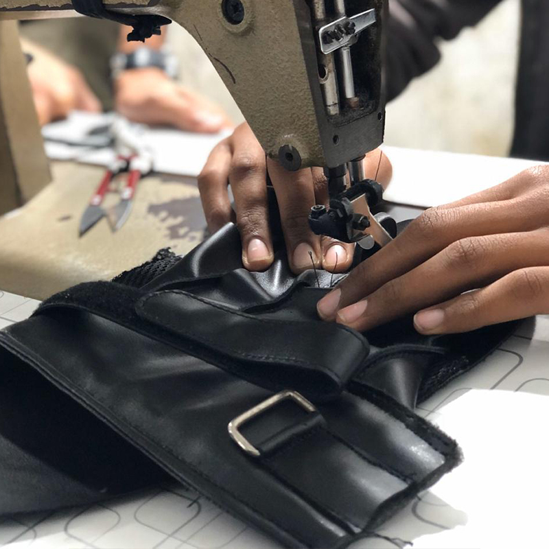 Industrial stitching on leather combat sports equipment at URWA manufacturing